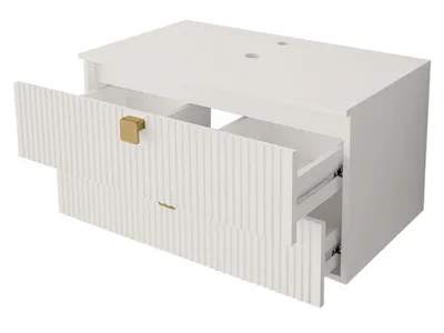 A white bathroom vanity with two drawers, one of which is partially open, revealing the interior and drawer slides. The vanity has gold-colored handles.