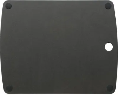 The back of a black cutting board with four rubber feet and a circular cutout.