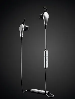 A pair of silver and black in-ear headphones with a wire connecting them, set against a black background.