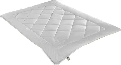 A white quilted comforter is shown from a diagonal angle against a white background.