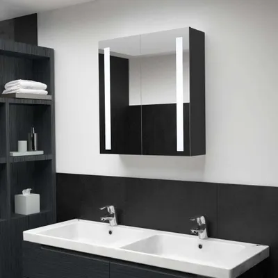 A modern bathroom with a double sink, faucets, and a mirrored cabinet with LED lights.