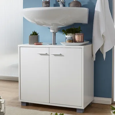 A white bathroom vanity cabinet with a sink mounted above it, against a blue wall.
