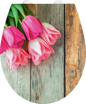A bouquet of pink tulips is arranged on a rustic wooden surface.