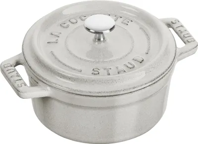 A close-up studio shot of a small, round, gray cast iron pot with a white lid and handle.