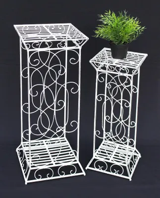 Two white metal plant stands of different heights against a black background.