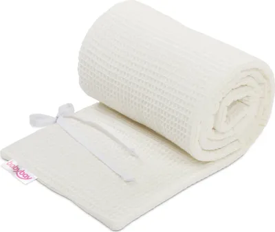 A rolled-up waffle-knit baby blanket on a white background.