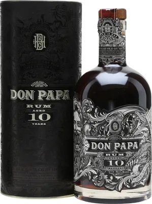 A bottle of Don Papa Rum 10 Years and its cylindrical packaging are displayed against a white background.