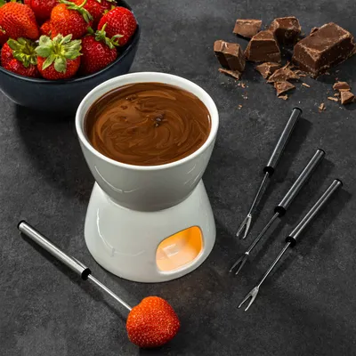 A chocolate fondue set with strawberries and chocolate chunks.