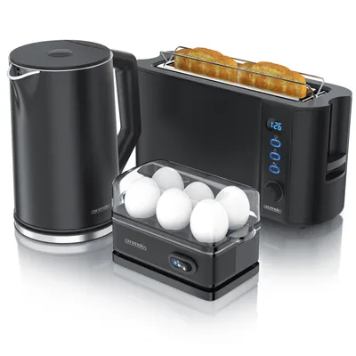 A black electric kettle, a black toaster with toast, and a black egg cooker with eggs are arranged on a white surface.