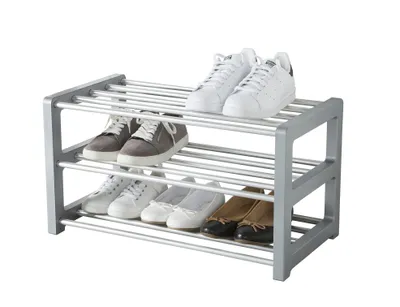 A three-tier shoe rack filled with various shoes, presented against a white background.