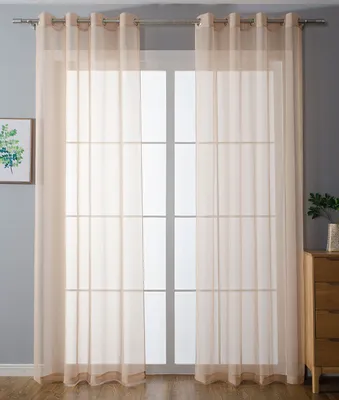 A window covered by sheer curtains, with a small framed picture on the left and a wooden dresser on the right.