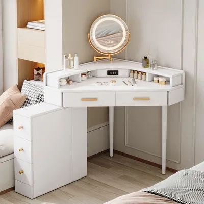 A white corner vanity table with a lighted mirror and various cosmetic products on top.