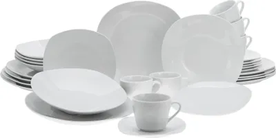 A collection of white ceramic dinnerware, including plates, bowls, and cups, arranged on a white background.