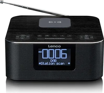 A black Lenco DAB+/FM radio alarm clock with a wireless charging pad on top, shown from the front.