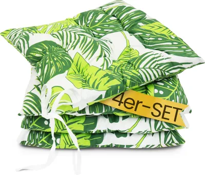 A stack of four green and white leaf-patterned seat cushions tied together with a white ribbon.