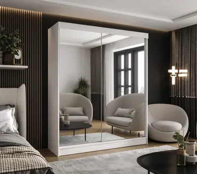 A bedroom scene with a large mirrored wardrobe, two chairs, and a bed.