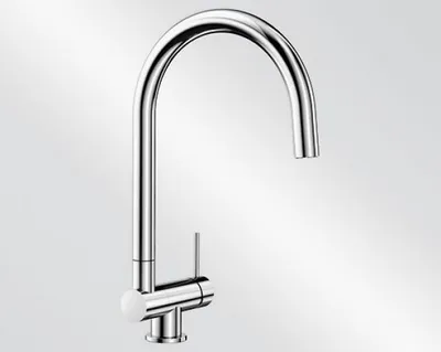 A studio shot of a chrome kitchen faucet against a gradient background.