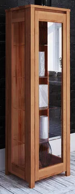 A tall, narrow wooden display cabinet with glass doors and shelves, standing against a dark brick wall.