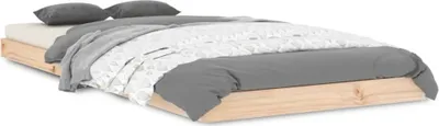 A wooden bed frame with bedding and pillows, shown from a diagonal angle on a white background.
