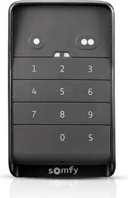 A black and gray Somfy remote control with a numeric keypad and two circular buttons at the top.