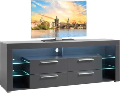 A modern gray TV stand with drawers and glass shelves, illuminated by blue LED lights, with a television displaying a cityscape on top.