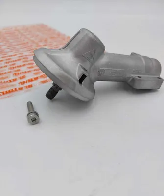 A metal gear housing and a screw on a light-colored surface.