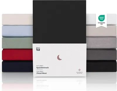 A stack of folded fitted sheets in various colors, with a product package in the foreground.