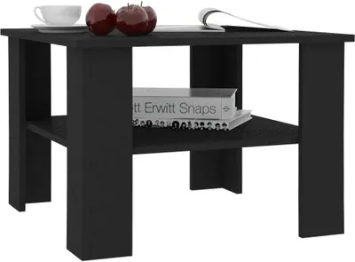 A black wooden side table with a shelf, holding a cup, two apples, and books.