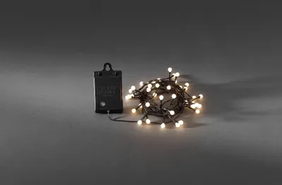 Produktbild von Konstsmide - LED Globelichterkette, runde Dioden, mit an/aus Schalter Lichtsensor und 6h und 9h Timer, 40 warm weiße Dioden, batteriebetrieben, Außen (IP44), schwarzes Kabel, 4 x AA 1.5V (exkl.); 3740-100