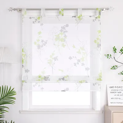 A transparent floral curtain hanging on a window.