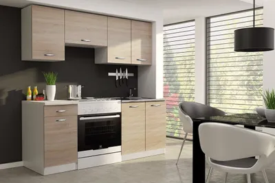 A modern kitchen unit with light wood effect cabinets and white accents, set against a dark wall and a large window with blinds.