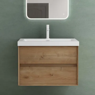 A bathroom vanity with a sink and faucet against a green wall.