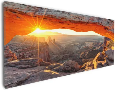 Produktbild von Wallario Premium Leinwandbild Sonnenstrahl am Horizont  Leuchtende Felsspalte in Größe 30 x 75 cm