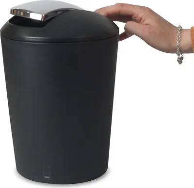 A hand is shown opening a black trash can with a silver lid.