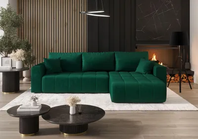 Modern living room with a plush green sectional sofa in front of a fireplace and wood-paneled wall.
