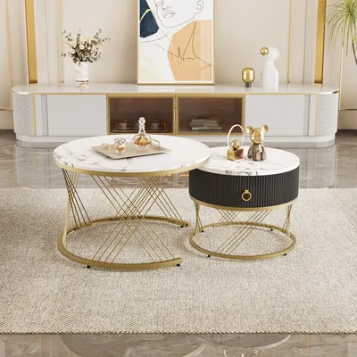 A set of two round coffee tables with marble-look tops and gold metal frames, placed on a rug in a living room setting.