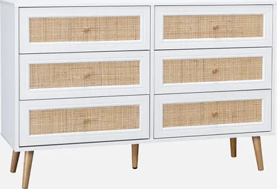 A white dresser with woven drawer fronts and wooden legs.