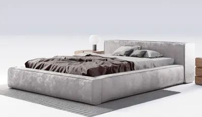 A modern upholstered bed with a headboard, two pillows, and a duvet, placed on a rug against a white background.