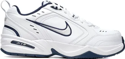 A white Nike Air Monarch IV shoe with navy accents, shown from the side against a white background.