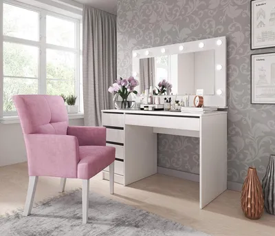 A vanity table with a lighted mirror and a pink chair in a bedroom.