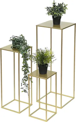 Three gold metal plant stands of varying heights, each holding a potted plant.
