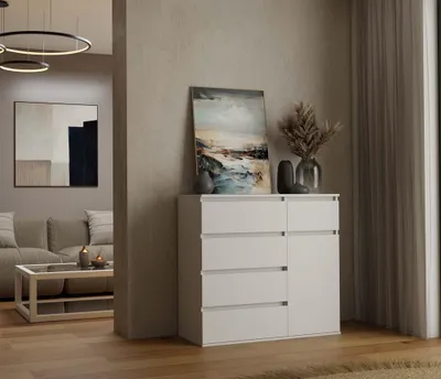 A modern living room with a white dresser, artwork, and a sofa in the background.