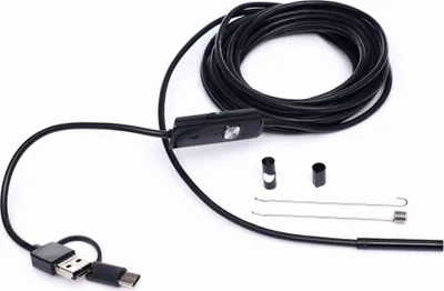 A black inspection camera with a long cable and USB connectors is laid out on a white background. Several small accessories are placed near the camera head.