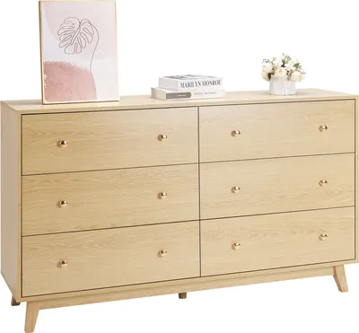 A light wood dresser with six drawers is shown against a white background. Decorative items are placed on top.