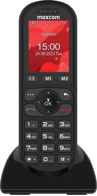 A black Maxcom Comfort MM39D 4G desk phone is shown in its charging cradle against a white background.