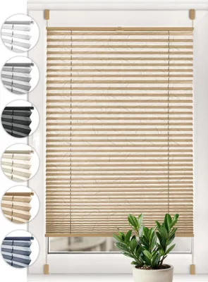 A window with beige pleated blinds and a small green plant in a pot in front of it. Swatches of different colored blinds are shown on the left side of the image.