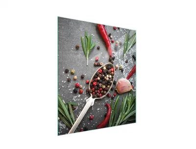 A close-up overhead shot of a glass cutting board with various spices, herbs, and chili peppers.