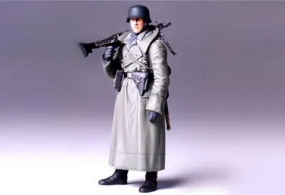 Zdjęcie produktu dla Tamiya 1:16 Figurka z II wojny światowej Niemiecki żołnierz w płaszczu i z karabinem maszynowym