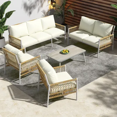 An outdoor patio setting with a rattan furniture set including a sofa, loveseat, two chairs, and a coffee table.