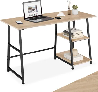 A desk with a laptop, mouse, phone, and books on shelves.